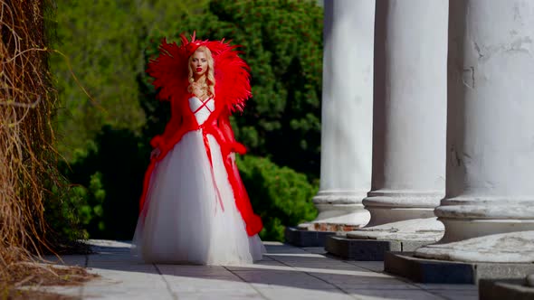 Red Queen is Walking in Royal Garden at Sunny Day Fairytale and Fantasy Costumed Performance