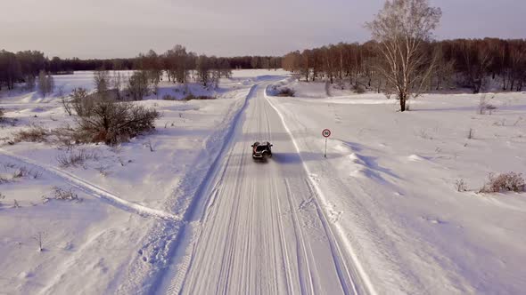 Burgundy car on snowy road