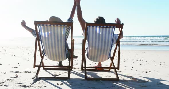 Senior couple relaxing on sunlounger at beach