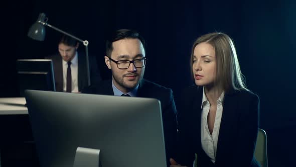 Two businesspeople looking at screen, talking