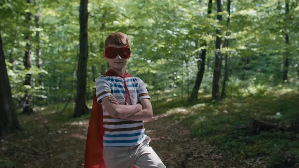 Ginger caucasian boy wearing superhero costume standing with garbage bags. Shot with RED helium came