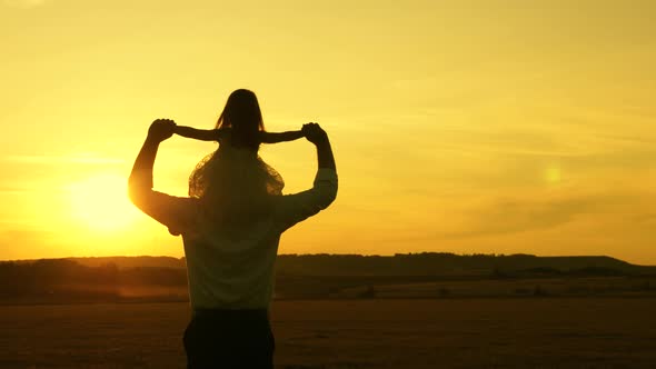 Father and Daughter Are Dancing in the Meadow in the Sun.dad Carries a Little Kid on Her Shoulders