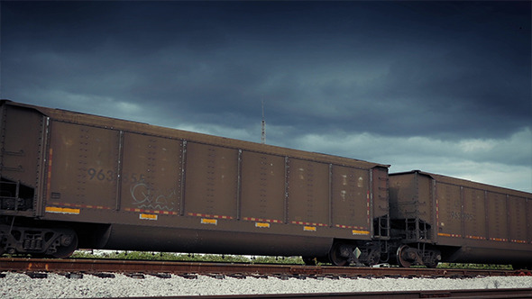 Freight Train Carriages Passing Dramatic Sky