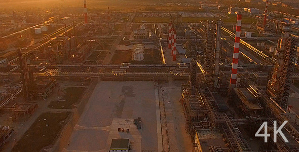 Huge Industrial Plant with Pipes at Sunset