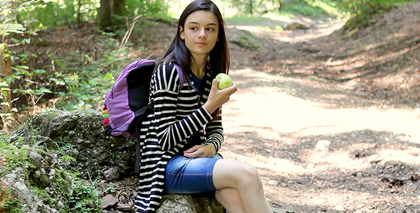 Teenager Tourist Girl Eating Apple in Forest