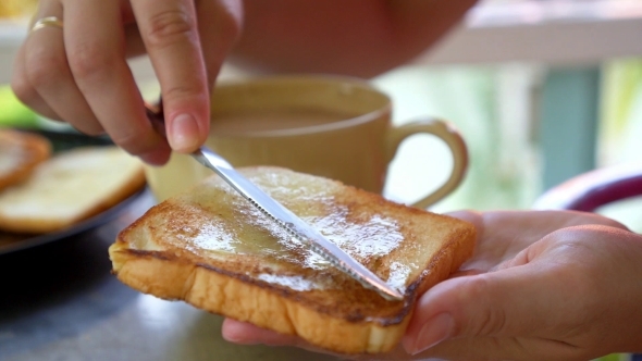 Female Hands Making Toast With Butter And Jam