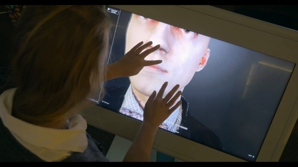 Womam Looking At 3D Human Model On Touchscreen