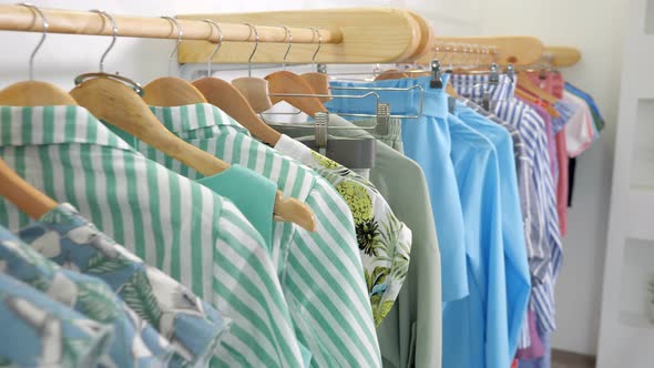 Wooden Hangers with Fashionable Colorful Clothes on Rack