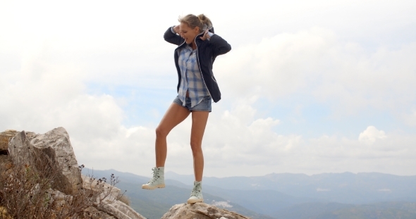 Sporty Woman Standing On Top Of Rock