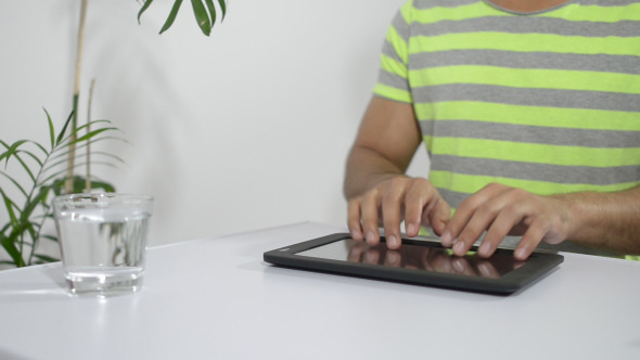 Young Man Typing on Tablet PC