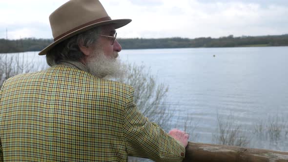 An old man looking out over the lake thinking about his history