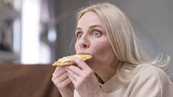 Hungry Excited Woman Biting Slice of Pizza Fast Chewing with Satisfied Facial Expression