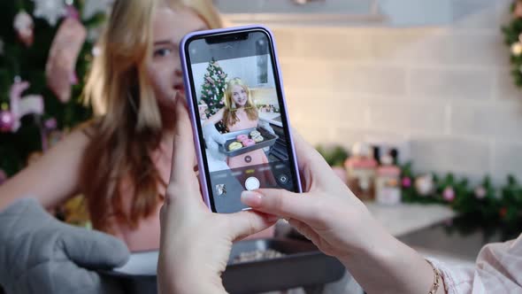 Happy Family Christmas a Girl Standing with Baking Sheet and Her Mom Taking Pictures of Her on the