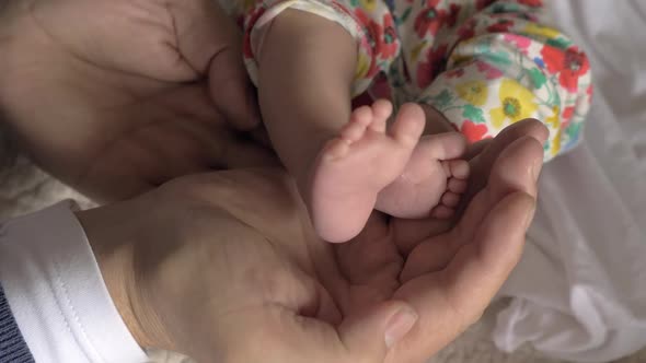 Dad Holding Baby Feet in Hands