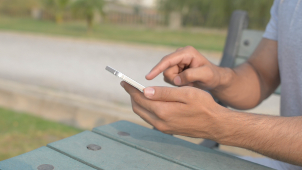Young Man Using Apps on Smartphone alt