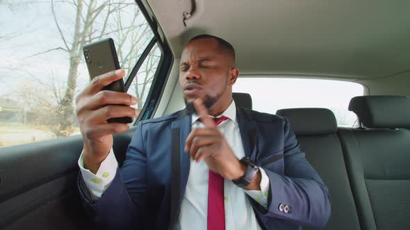 Irritated Businessman Arguing in Car During Video Phone Call