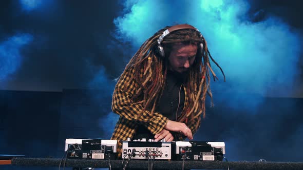 Club DJ Playing Mixing Music on Turntable at Party