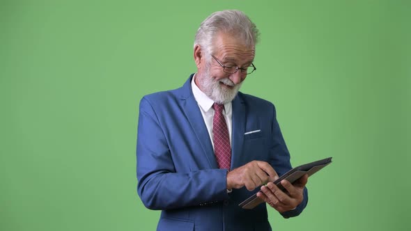 Handsome Senior Bearded Businessman Against Green Background