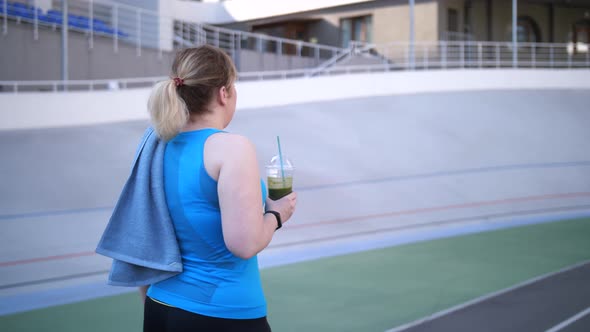 Plus Size Woman Jogger Walking with Smoothie Drink