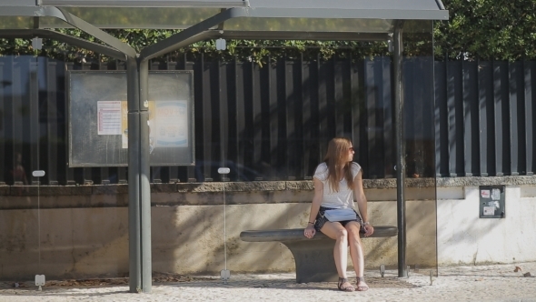 Lonely Young Girl Waiting At Bus Stop In Skirt