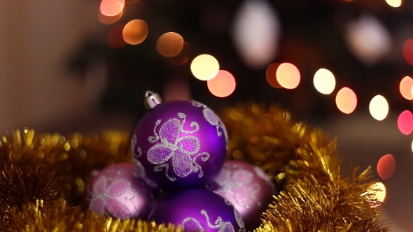 Three Purple Christmas Balls On a Bokeh Light