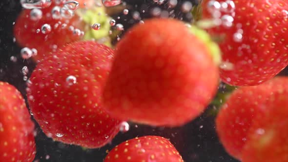 Strawberry Spinning and Splashing Into Water on Black Background