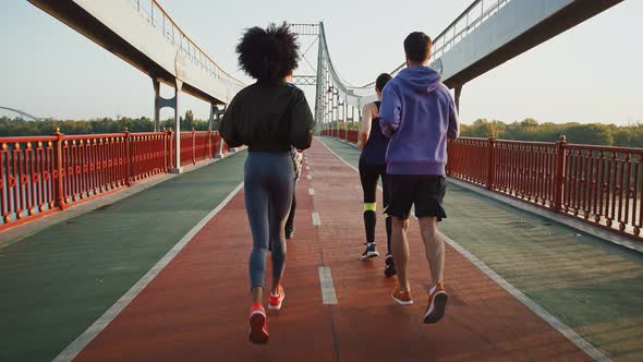 Back View of People Group Practicing Morning Run Workout on Sport Bridge Slow Motion