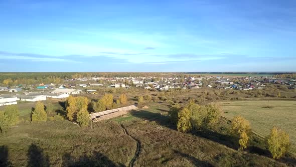 Aerial Large Village with Livestock Complex Under Blue Sky