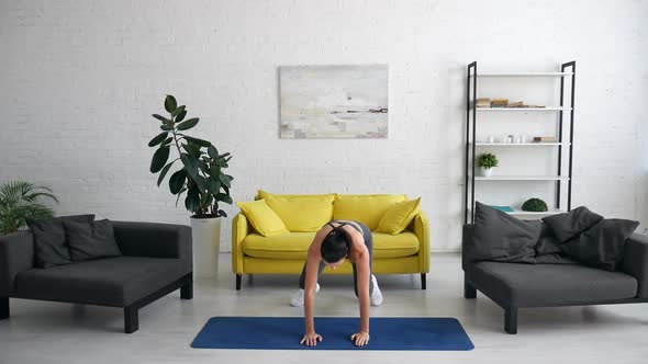 Beautiful Young Woman Does Exercises for the Abdomen on the Rug in the Room