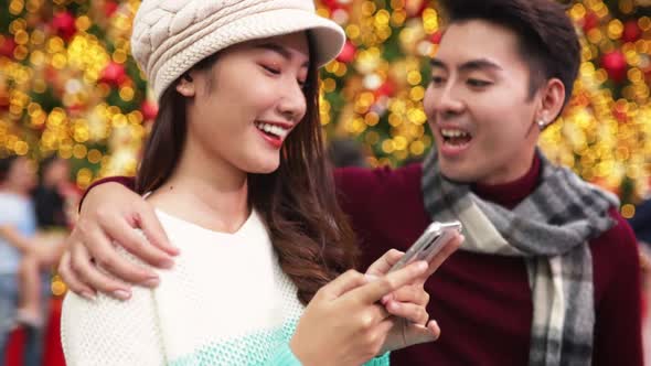 Merry Christmas and Happy New Year. Young  asian couple with Christmas lights