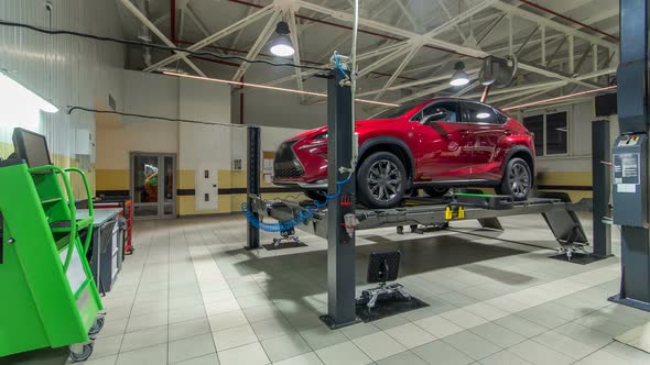 Car on Stand with Sensors on Wheels for Wheels Alignment Camber Check in Workshop of Service Station