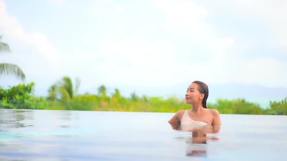 Young asian woman enjoy around outdoor swimming pool for leisure