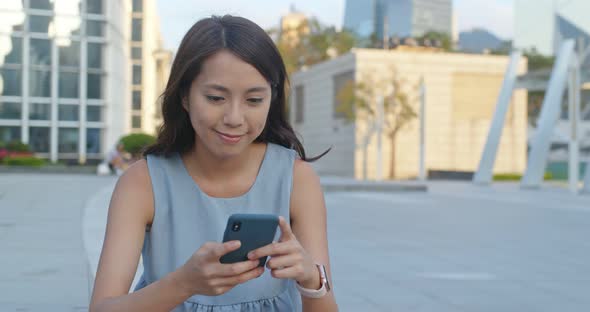 Woman use of mobile phone for online in city