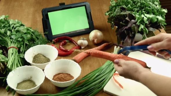 woman watches the recipe on the tablet