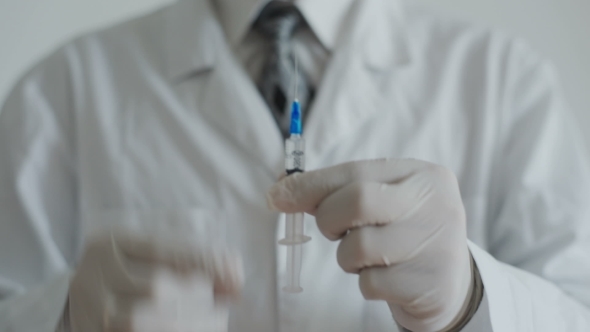 Doctor With Syringe Is Preparing For Injection