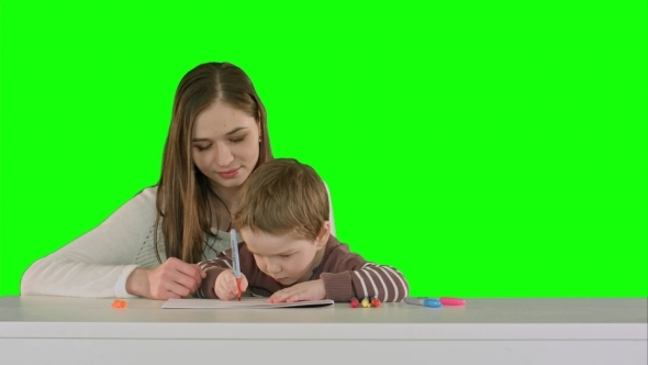Mom And Kid Boy Painting Together On Table On a