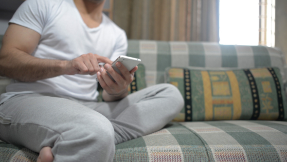 Casual Relax Man Using Smartphone on Sofa