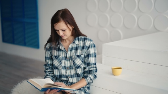 Young Woman Reading Book And Smiling