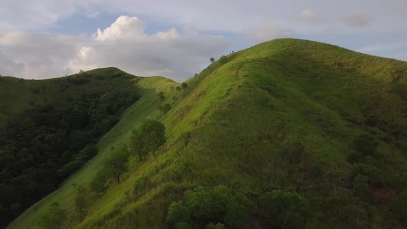 Flight over Green Grassy Rocky Hills