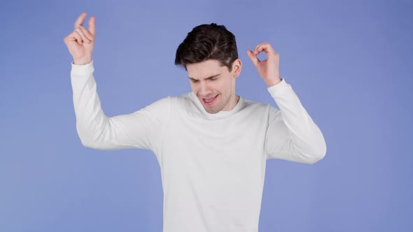 Young Man Dancing Positive on Purple Studio Background