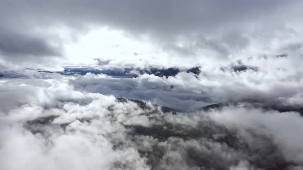 Flight Through Blue Sky with Clouds Over Mountain