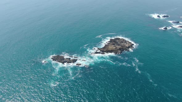 Aerial view of rocky islands washed by calm ocean waves on Java coast Indonesia