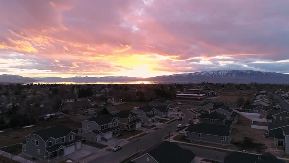 Sunset aerial view flying up and over houses in neighborhood