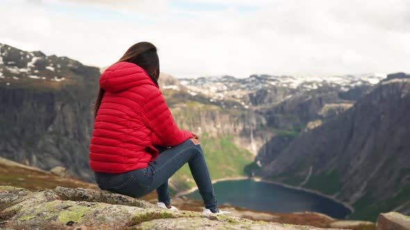 Woman in Red Jacket Admiring the View on Top of a Mountain