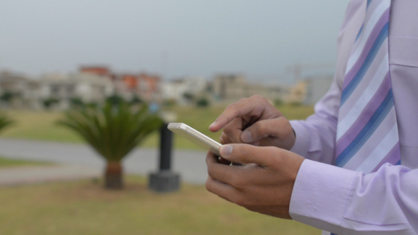 Businessman Using Smartphone in Park