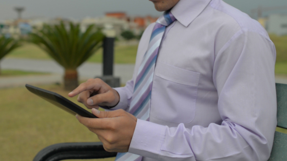 Man on bench Using Tablet PC