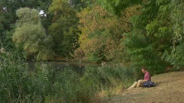 Man Sitting at The Lake Looking in Front of Him