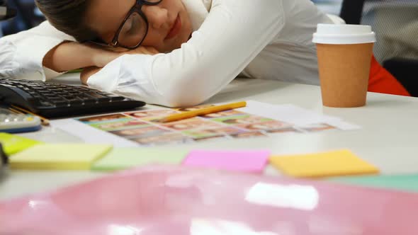 Female graphic designer sleeping at desk