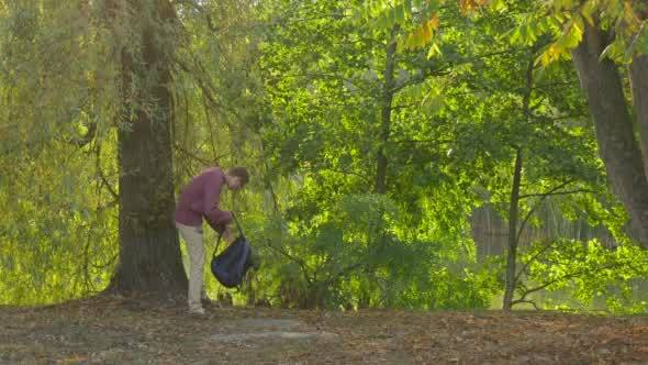 Man With Backpack Comes And Sits Under The Tree