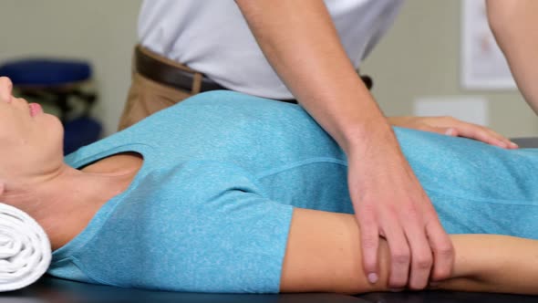 Male physiotherapist giving arm massage to female patient